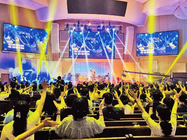 ‘2022 코스타(KOSTA) 월드’ 참가자들이 16일 부산 수영로교회에서 찬양 사역자 브라이언킴의 무대를 보며 찬양하고 있다.