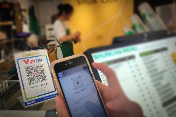 A customer pays at a coffee shop using a QR code. — VNS Photo Đoàn Tùng