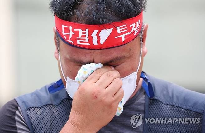 눈물 흘리는 김경선 본부장 (서울=연합뉴스) 김도훈 기자 = 전국민주노동조합총연맹(민주노총) 공공운수노조 화물연대 대전지역본부 김경선 본부장이 16일 서울 강남구 하이트진로 본사 앞에서 고공농성돌입 기자회견 발언을 마친 뒤 눈물을 훔치고 있다. 2022.8.16 superdoo82@yna.co.kr