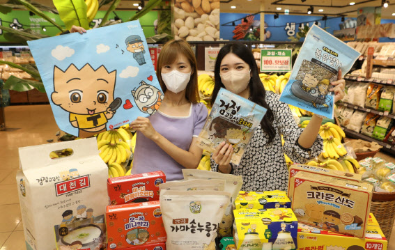 롯데마트 모델들이 서울역점에서 ‘검정고무신’ 컬래버레이션 패키지 상품을 홍보하고 있다.(사진=롯데마트)