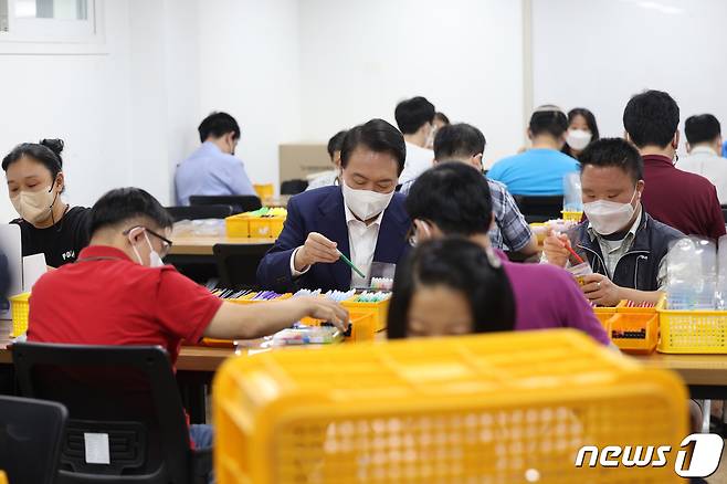 윤석열 대통령이 18일 오후 서울 강남구 충현복지관 보호작업장에서 발달장애인 훈련생 및 근로인들과 색연필 포장 작업을 체험하고 있다. (대통령실 제공) 2022.8.18/뉴스1 ⓒ News1 오대일 기자