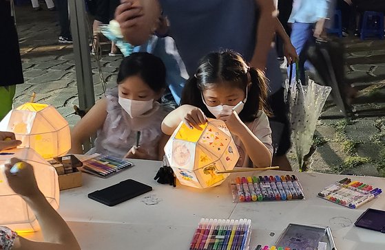 신라달빛기행에 참가한 아이들이 백등에 그림을 그려 넣고 있다. 표정이 아주 진지하다.