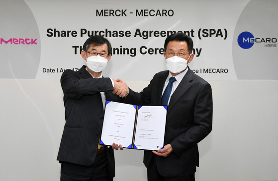 Kim Woo-kyu, left, managing director of Merck Korea, and Lee Jae-jung Lee, Mecaro CEO, pose for a photo during a signing ceremony on Wednesday. [MERCK KOREA]