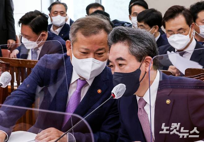 이상민 행정안전부 장관과 윤희근 경찰청장이 18일 서울 여의도 국회에서 열린 행정안전위원회 전체회의에서 대화를 나누고 있다. 윤창원 기자