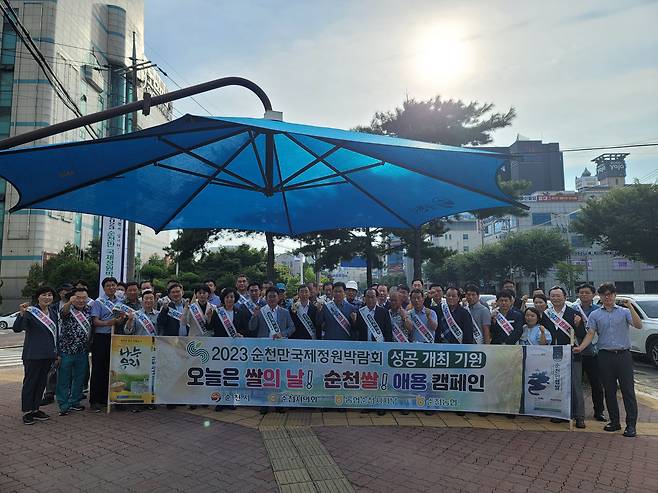 순천 조례사거리에서 열린 쌀 소비촉진 및 2023순천만국제정원박람회 성공개최 홍보 캠페인에 참가자들이 파이팅을 외치고 있다. 김진남 전남도의원, 김영진 순천시의회 문화경제위원장, 이향기, 신정란, 이세은 순천시의원, 이기장 순천농협 홍보대사와 농민단체, 전업농대표 등 60여명이 함께했다.