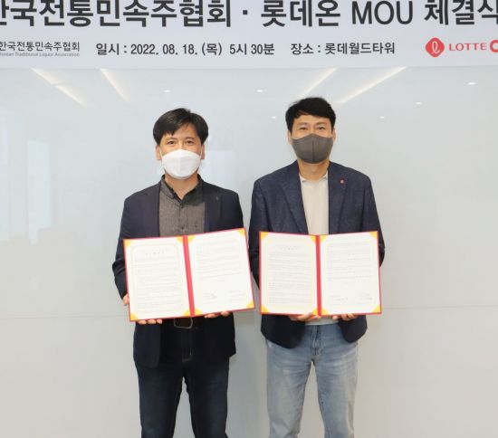 김장규 롯데온 상품부문장(오른쪽)과 최성호 한국전통민속주협회장이 기념 사진을 찍고 있다.