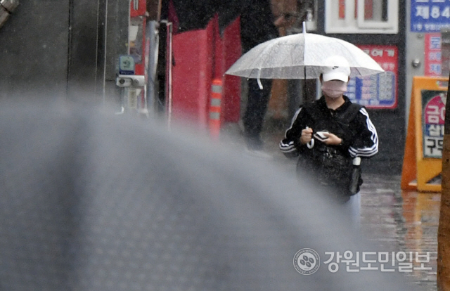 ▲ 춘천 명동에서 우산을 쓴 한 시민이 길을 걷고 있다. [강원도민일보 자료사진]
