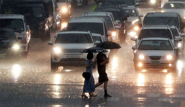 19일 오후 서울지역에 60㎜ 이상 폭우가 쏟아진 가운데 서울 을지로3가역 인근에서 시민들이 우산을 쓰고 분주히 발걸음을 옮기고 있다. [사진 출처 = 연합뉴스]