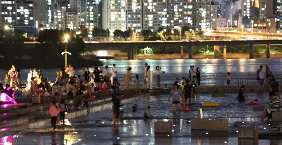 서울 전역에 폭염주의보가 발령된 20일 여의도한강공원에서 열대야를 피해 강변에 나온 시민들이 더위를 식히고 있다.