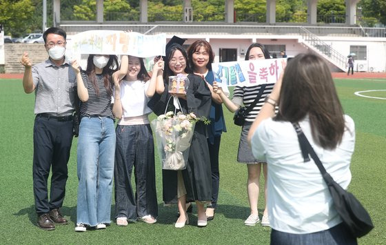 19일 경남 창원시 창원대학교에서 열린 2022년 학위 수여식에서 졸업생이 가족, 친구와 함께 촬영하고 있다.   창원대는 신종 코로나바이러스 감염증(코로나19) 확산으로 중단했던 학위수여식(졸업식)을 이날 3년 만에 개최했다. 연합뉴스