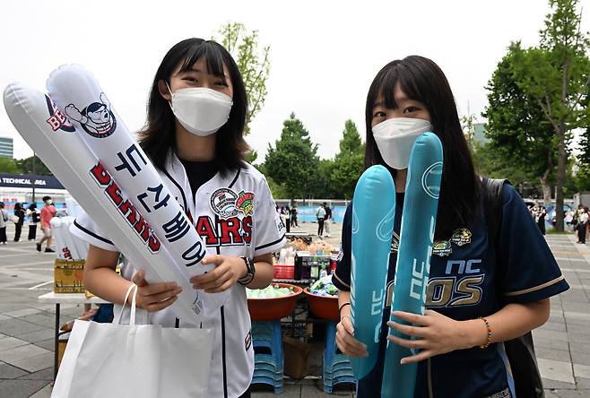 Baseball fans wearing the jerseys of the Doosan Bears (left) and NC Dinos pose for a photo before a game held at Seoul Sports Complex in Songpa-gu, southern Seoul, on Aug. 10. (Im Se-jun/The Korea Herald)