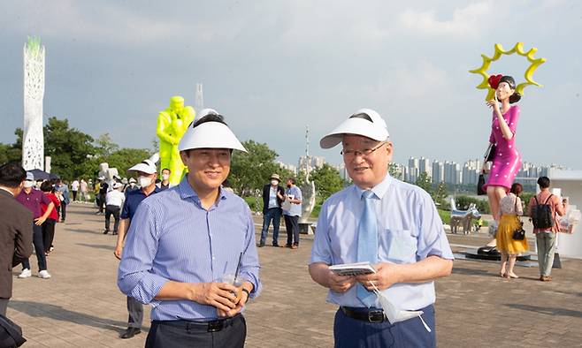 지난 20일 서울 뚝섬 한강공원에서 ‘2022 한강조각프로젝트-낙락유람(樂樂遊覽)’ 작품을 둘러보고 있는 오세훈 서울시장(왼쪽)과 K-스컬프쳐(K-Sculpture) 조직위원장인 윤영달 크라운해태제과 회장. 크라운해태제과 제공