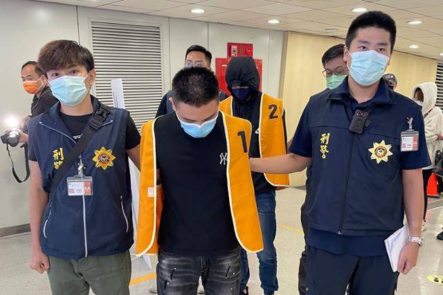 18일 대만 범죄수사국 경찰이 태국에서 체포한 '대만인 캄보디아 취업 사기 사건' 용의자(가운데)를 태국에서 체포해 대만 타이완 부근의 타오위안 국제공항을 통해 호송하고 있다. 타이완=AP 연합뉴스