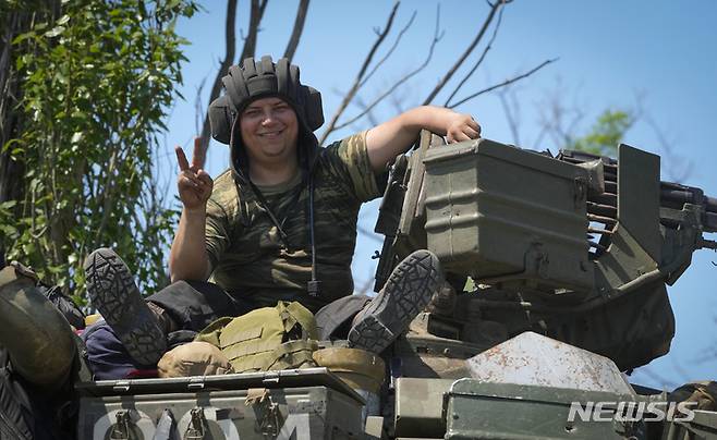 [도네츠크=AP/뉴시스] 20일(현지시간) 우크라이나 도네츠크에서 우크라이나 군인이 전차에 올라 승리의 V를 그리며 웃고 있다. 2022.06.21.