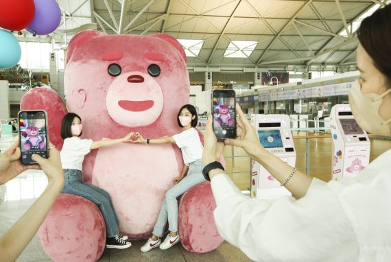 롯데홈쇼핑이 인천국제공항에서 '벨리곰' 캐릭터를 활용한 마케팅을 진행하고 있는 가운데, 여행객들이 '벨리곰' 조형물 앞에서 인증 사진을 촬영하고 있다. 롯데홈쇼핑 제공