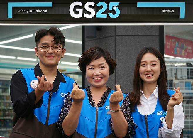 GS25 가맹 경영주와 임직원이 손하트를 만들며 포즈를 취하고 있다.(GS리테일 제공)