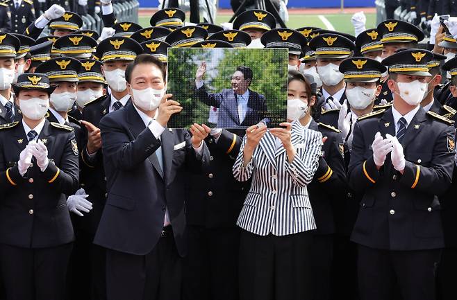 윤석열 대통령과 부인 김건희 여사가 19일 충청북도 충주 중앙경찰학교 대운동장에서 열린 중앙경찰학교 310기 졸업식에서 졸업생들에게 받은 선물을 들어 보이고 있다. [이승환 기자]