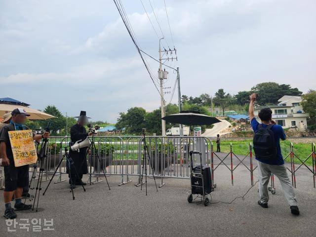 한국일보는 7월 16일부터 8월 14일까지 한달 간 주말마다 문재인 전 대통령의 양산 평산마을 사저 앞을 찾았다. 문 전 대통령 퇴임 후 보수단체와 1인 시위자, 유튜버들은 매일 사저 앞에서 집회를 계속하고 있다. 한 유튜버가 문 전 대통령 사저를 향해 자신이 작곡한 '쩝쩝이송'을 부르고 있다. 양산=조소진 기자