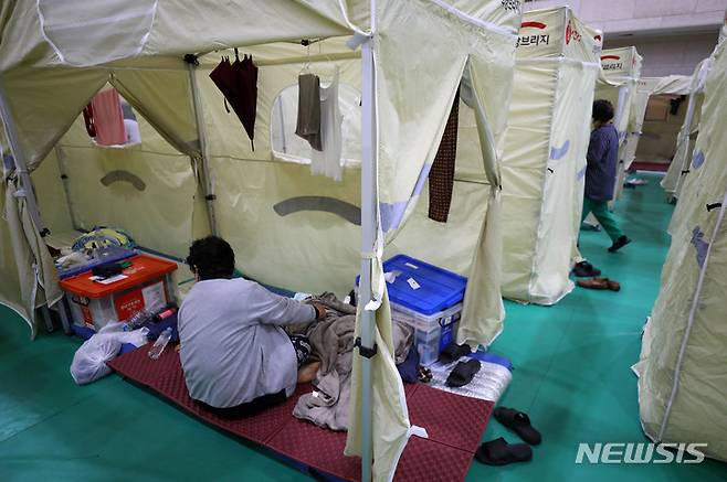[서울=뉴시스] 지난 11일 오후 서울 강남구 구룡중학교에 마련된 폭우피해 이재민대피소에서 이재민이 구호텐트 안에서 휴식을 취하고 있다. 2022.08.11. livertrent@newsis.com