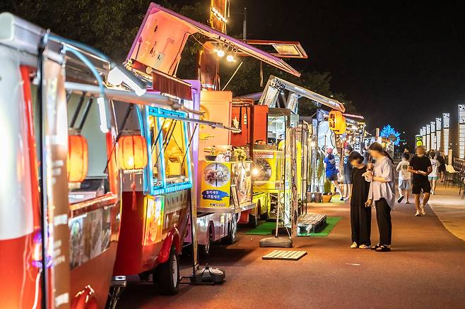 순천 동천변 저류지 부근에서 11월 말까지 열리는 '순천만 달밤 야시장'. 20여대의 푸드 트럭의 조명과 버스킹 공연이 순천의 달밤을 수놓는다. / 이신영 영상미디어 기자