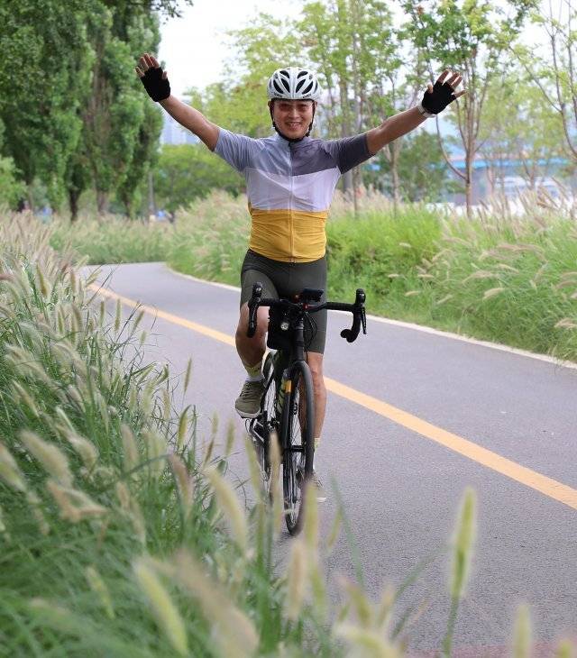 신용락 변호사가 서울 한강공원에서 사이클을 타며 두 팔을 들어 올리고 있다. 골프와 등산, 사이클로 건강을 다지는 그는 “투르 드 프랑스 등 세계적인 사이클 대회에서 1위로 통과하는 선수들과 똑같은 포즈를 하고 싶었다”고 했다. 이훈구 기자 ufo@donga.com
