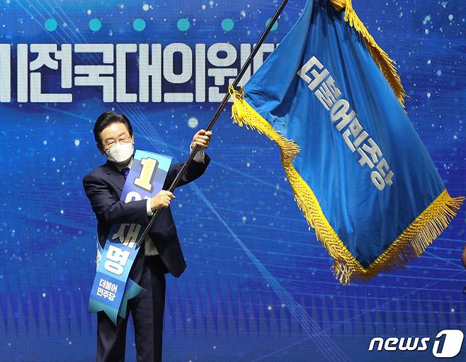 이재명 더불어민주당 신임 당대표가 28일 서울 송파구 올림픽 체조경기장에서 열린 제5차 정기전국대의원대회에서 당대표로 선출 된 뒤 당기를 흔들고 있다. 2022.8.28/뉴스1 ⓒ News1 허경 기자