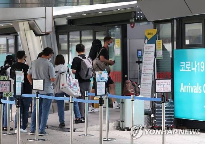 해외입국자 붐비는 공항 코로나 검사센터 지난달 27일 오후 인천국제공항 제1여객터미널 입국자 전용 코로나 검사센터 앞에서 해외 입국자들이 검사를 받기 위해 안내를 받고 있다. [연합뉴스 자료사진]