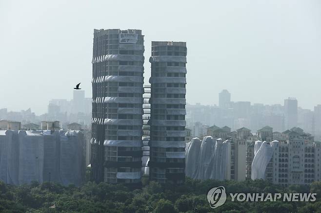 철거 전 모습 (노이다 로이터=연합뉴스) 28일 인도 노이다에서 폭파 방식으로 철거된 아파트 두 동의 철거 전 모습. 건물 파편으로부터 보호하기 위해 두 건물과 인근 건물들이 흰색 플라스틱 시트로 덮여 있다. 2022.8.28 photo@yna.co.kr