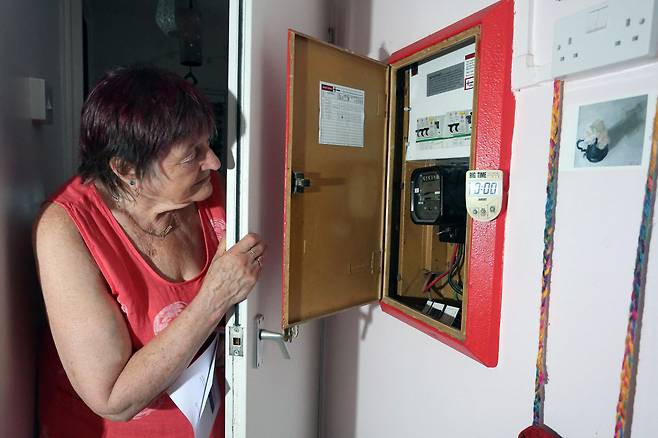 런던에 거주하는 한 영국 여성이 전기 계량기를 점검하고 있다.