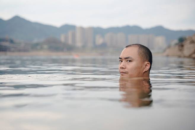 28일 중국 충칭의 장링강에서 한 남성이 수영을 하고 있다. 충칭/EPA 연합뉴스