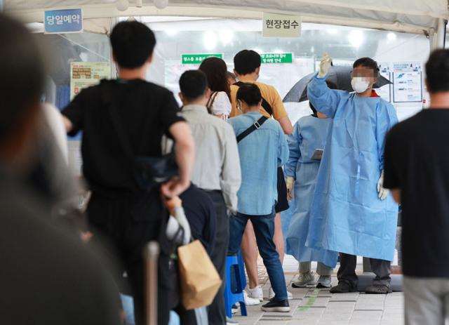 코로나19 신규 확진자 수가 4만3,142명을 기록한 29일 오전 서울 마포구보건소 선별진료소를 찾은 시민들이 검사를 위해 줄을 서 있다. 연합뉴스