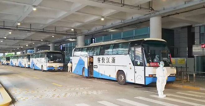 이우시 정부가 제공한 버스 10여 대가 항저우공항에 대기하고 있다.