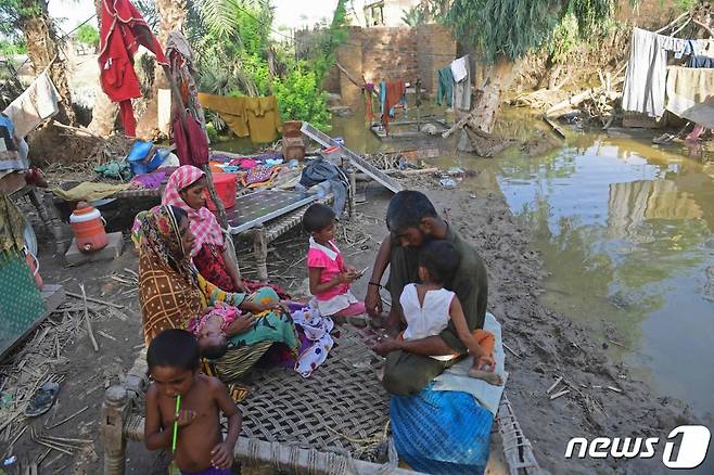 (수쿠르 AFP=뉴스1) 남해인 기자 = 28일(현지시간) 파키스탄 수쿠르에서 나히드 샤이크(사진 왼쪽)와 그의 가족들이 홍수로 폐허가 된 집 주변에 앉아있다. 파키스탄재난관리청이 발표한 수치에 따르면 이번 몬순 우기 홍수로 인한 사망자 수는 지난 6월부터 현재까지 1061명을 기록했다.   ⓒ AFP=뉴스1  Copyright (C) 뉴스1. All rights reserved. 무단 전재 및 재배포 금지.