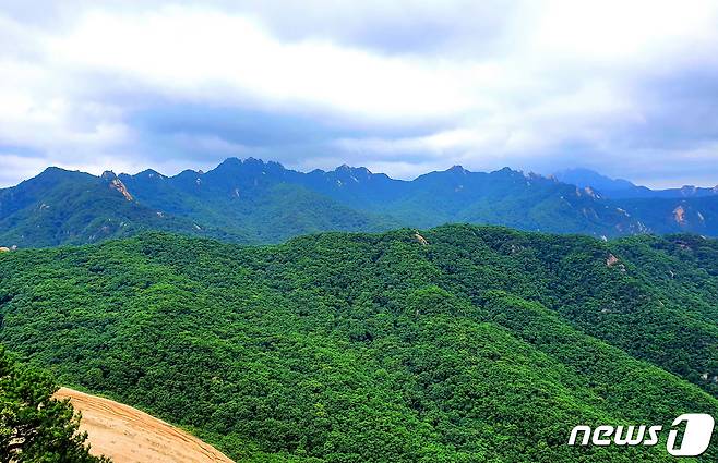 사패산에서 바라본 도봉산의 병풍처럼 펼쳐진 스카이라인. 오른쪽에 북한산 백운대가 구름에 가리우고 있다