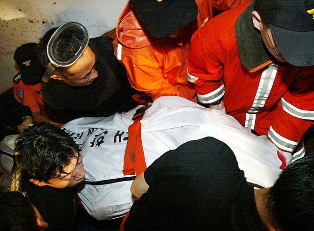 2003년 9월 13일 경남 마산시 합포구 해운플라자에서 군과 119 구조대원이 태풍 매미로 인한 해일로 사망한 희생자의 시신을 이송하고 있다. 마산=고영권 기자