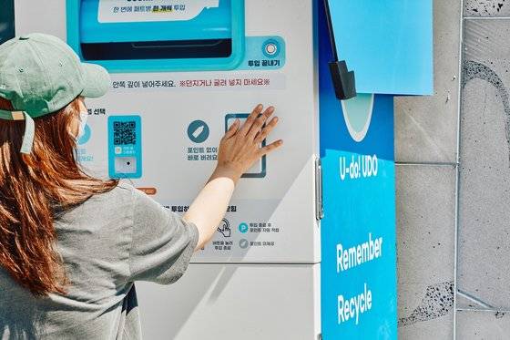 지난 8월 중순 제주 우도를 찾은 관광객이 페트병수거기를 사용하고 있다. 사진 제주관광공사