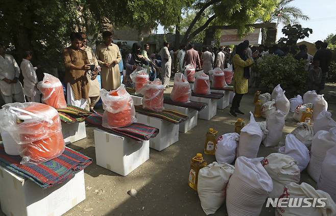 [시카르푸르=AP/뉴시스] 8월 31일(현지시간) 파키스탄 신드주 시카르푸르에서 세이브 더 칠드런 조직이 배포한 구호물자를 받으려는 수재민들이 줄을 서고 있다. 파키스탄 '최악의 홍수'로 1100명 이상이 숨지고 국토 3분의 1이 침수된 가운데 현지 당국은 콜레라 등 수인성 질병 확산을 우려하고 있다. 2022.09.01.