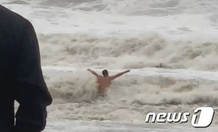 6일 오전 6시께 태풍 힌남노의 영향으로 파도가 높게 일고 있는 해운대에 한 외국인 남성이 뛰어들었다. (온라인 커뮤니티 갈무리)