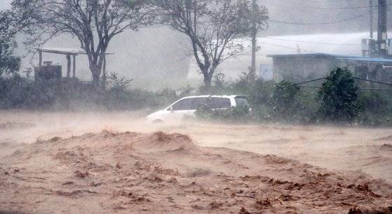 태풍 '힌남노'로 많은 비가 내리면서 6일 오전 경북 포항시 남구 장기면 수성천의 물이 불어나면서 주변에 세워둔 차량이 위태로운 모습을 보인다. 연합뉴스