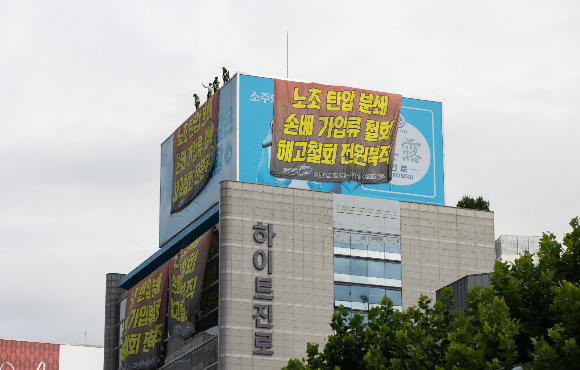 민주노총 공공운수노조 화물연대가 하이트진로와 잠정 합의했다. 사진은 지난달 24일 서울 강남구 하이트진로 본사 옥상에서 고공 농성을 하는 화물연대 모습. /사진=뉴스1