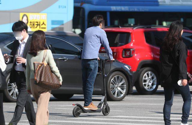 서울의 한 도심 거리에서 한 시민이 전동킥보드를 타고 이동하고 있다. 뉴시스