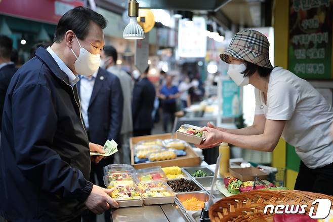 윤석열 대통령이 추석 연휴 첫날인 9일 서울 종로구 통인시장을 찾아 구절판을 구입하고 있다. (대통령실 제공) 2022.9.9/뉴스1 ⓒ News1 안은나 기자