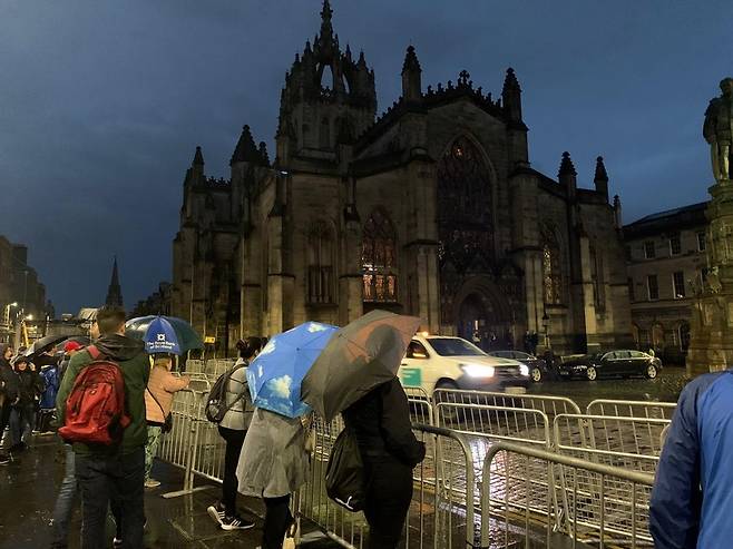 여왕 안치될 성 자일스 대성당을 지켜보는 관광객들 (에든버러=연합뉴스) 최윤정 특파원 = 영국 스코틀랜드 에든버러에서 11일(현지시간) 여왕 첫 장례 행렬을 앞두고 경찰이 도로를 통제하고 있다. 2022.9.11 merciel@yna.co.kr