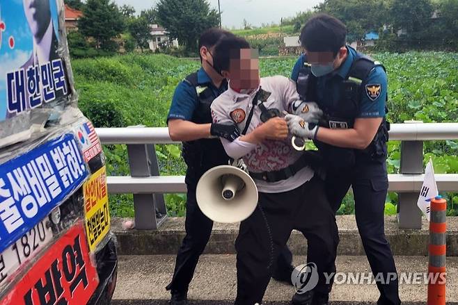 경남 양산경찰서 경찰관들이 16일 문재인 전 대통령 비서실 인사를 커터칼로 협박하는 등 소란을 피운 평산마을 장기 1인 시위자를 특수협박 혐의로 체포하고 있다. 평산마을 주민 페이스북 캡처.