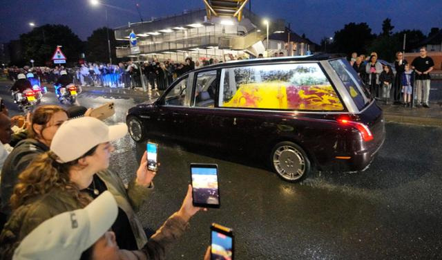 지난 8일 별세한 엘리자베스 2세 영국 여왕의 관을 실은 운구차가 13일 밤 버킹엄궁으로 들어오고 있다. 런던=AP