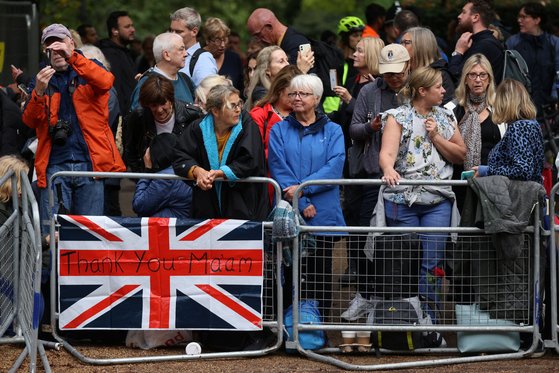 영국 시민들이 14일 엘리자베스 2세 여왕의 관이 버킹엄궁을 나와 웨스트민스터 사원으로 향하는 길목인 더몰 거리에 나와있다. 로이터=연합뉴스