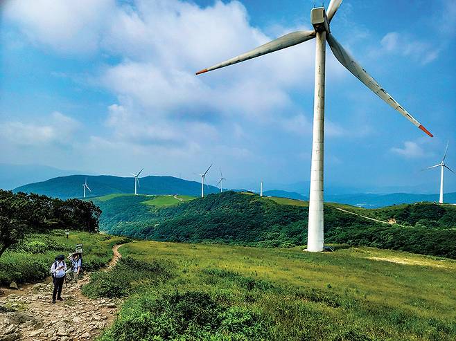 선자령을 오르는 등산인들. 백두대간의 광활한 초원 위에 세워진 풍력발전기가 눈길을 잡아챈다.