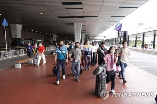 일본 정부가 코로나19 이후 지난달 단체 관광객 수용을 재개한 가운데 첫 한국인 단체 관광객이 7월 6일 수도권 관문인 지바현 소재 나리타국제공항에 깃발을 든 가이드를 따라 이동하고 있다. <나리타=연합뉴스>