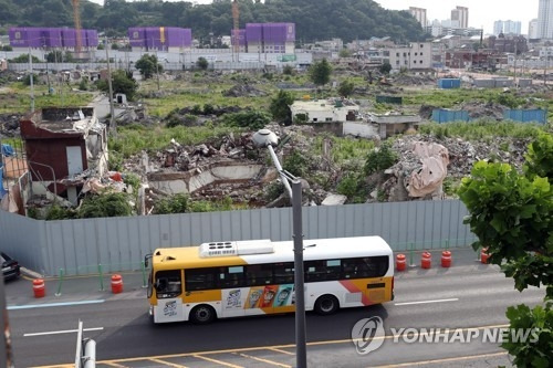 ‘학동참사’ 1주기를 맞은 지난 6월 9일 오후 광주 동구 학동4구역 재개발 사업지 사고 현장 앞으로 참사 당시 희생자들이 탑승했던 운림 54번 시내버스가 지나가고 있다./연합뉴스