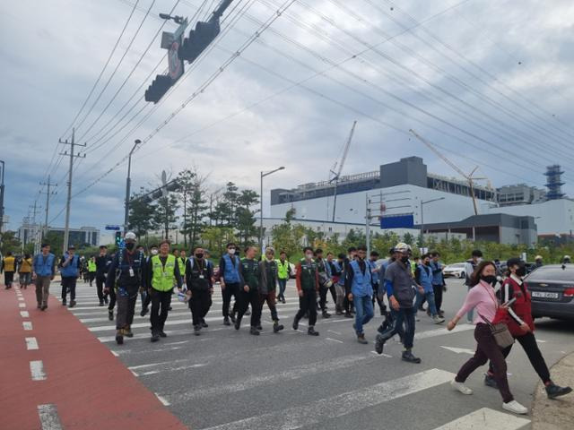 13일 오후 충북 청주시 흥덕구 청주테크노폴리스 내 SK하이닉스 M15 공장에서 반도체 생산설비 구축 일과를 마친 기술자와 인부들이 쏟아져 나오고 있다. SK하이닉스 측은 이곳 공사 현장에 하루 약 8,000명의 인력을 투입하고 있다. 다음 달 M15X 공장 증설이 시작되면, 하루 1만 명 이상의 인력이 투입될 예정이다.